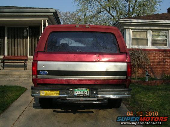 Red Ford Bronco rear view, silver stripe on tailgate, yellow bumper sticker