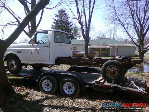 White truck chassis on trailer, side view
