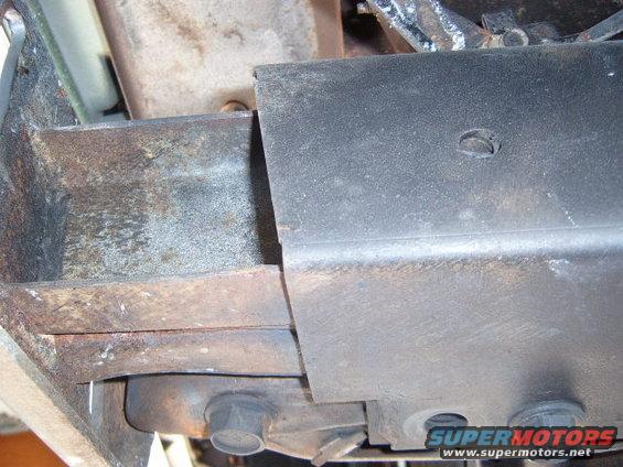 Vehicle frame components with rust and a black metal cover plate
