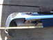 1973 Ford Ranchero - A chrome bumper is measured with a tape measure against a concrete surface.