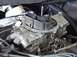 1968 Ford Mustang - A detailed view of a vehicle's carburetor, showing its intricate mechanical parts.