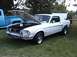 1968 Ford Mustang - A white 1968 Ford Mustang coupe is displayed with its hood open, next to a blue pickup truck.