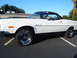 1973 Ford Ranchero - A white 1973 Ford Ranchero pickup truck is shown from the side, parked in a lot under a clear blue sky.