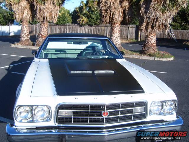 Front view of a white and black 1973 Ford Ranchero with a black hood scoop