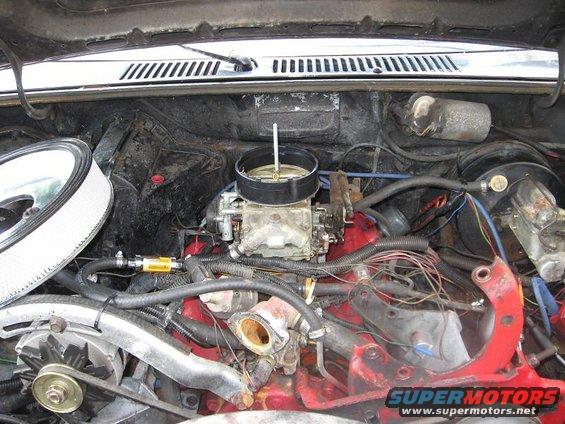 Engine bay with carburetor and air filter. SuperMotors.net logo visible