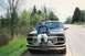 1994 Ford F-150 - Person sits on the hood of a 1994 Ford F-150 parked on the shoulder of a road.
