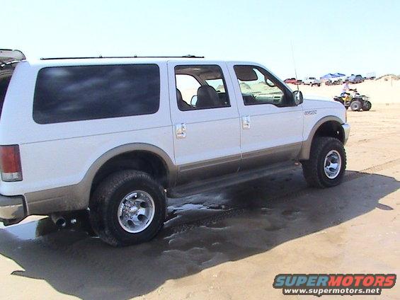 White 2000 Ford Excursion side view on sand