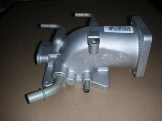 Silver Ford intake manifold with hoses and a barcode sticker