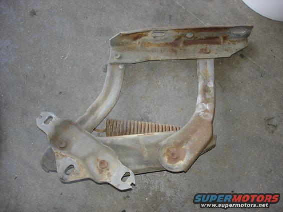 Rusted hood hinge assembly with spring, likely for a truck