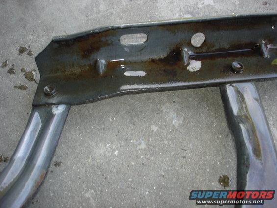 Metal frame part with pipes, showing rust and liquid