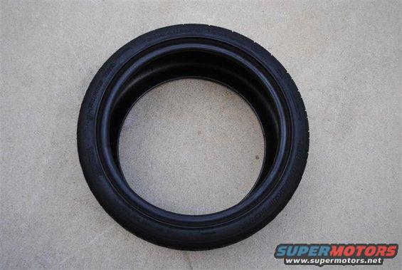 Tire on concrete surface. Supermotors.net logo in corner