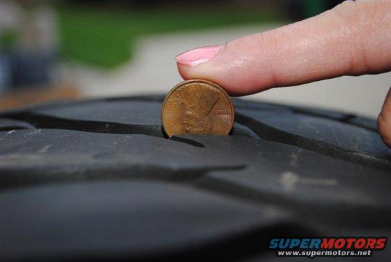 Penny inserted into tire tread to measure depth