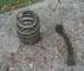 1976 Ford Ranchero - Suspension components, including a coil spring and a control arm, lie on a concrete surface.
