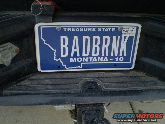 License plate on a dark-colored vehicle's rear bumper