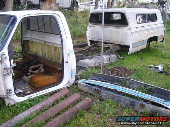 Disassembled 1979 Chevrolet C/K Pickup truck cab and bed sections in a yard