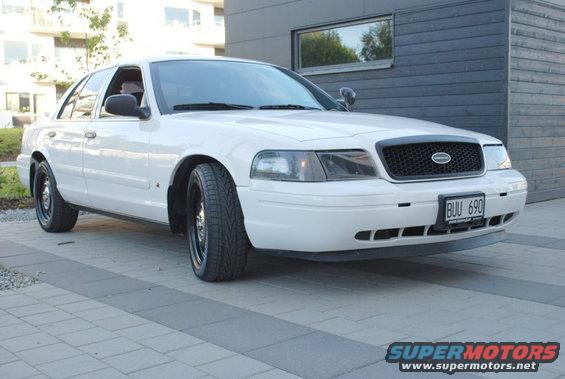 White 1998 Ford Crown Victoria sedan with black wheels parked on a paved driveway