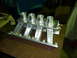 1984 Ford Bronco - Custom aluminum intake manifold with four carburetor mounts sits on a workbench.