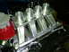 1984 Ford Bronco - Custom aluminum intake manifold with four carb openings, installed on an engine.