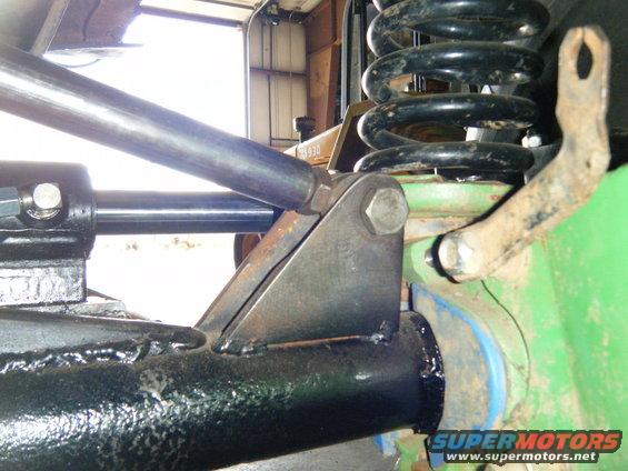 Close-up of a suspension component, possibly a shock absorber mount, with a large coil spring