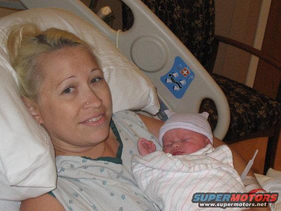 Woman holding a newborn baby in a hospital bed