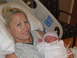 2001 Pontiac Trans Am - A woman smiles while holding her newborn baby, wrapped in a blanket and wearing a hat.