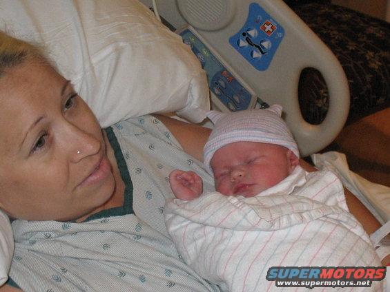 Newborn baby sleeping on mother's chest in hospital bed