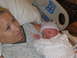 2001 Pontiac Trans Am - A mother cradles her newborn baby shortly after birth, with hospital equipment visible in the background.