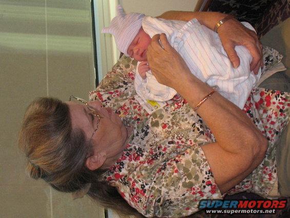 Woman holding a newborn baby wearing a striped hat