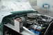 1979 Ford F-150 - The engine compartment of a truck is shown, with various parts and a container of fluid visible.