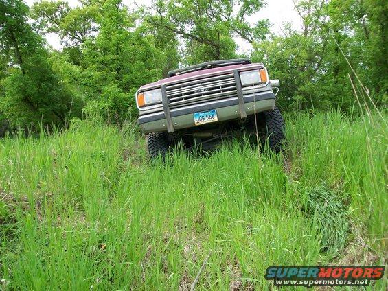 1988 Ford F-150 front view driving off-road through tall grass, license plate JOG 566