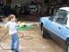 1989 Ford Bronco - A boy washes a blue convertible in a garage.