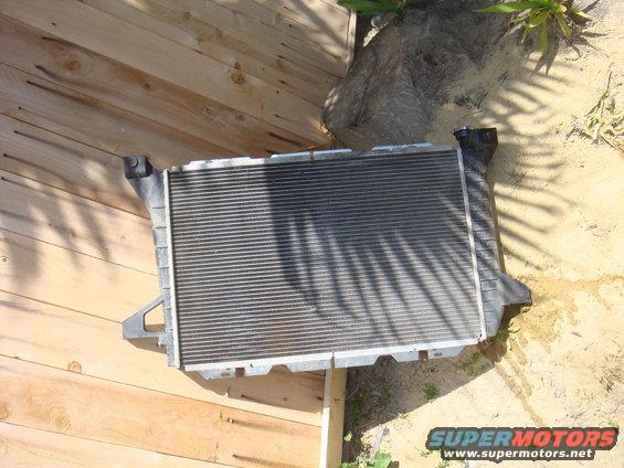 Radiator with black plastic end tanks, resting on wooden planks
