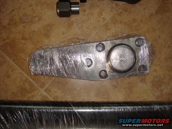 Metal part wrapped in plastic, with a bolt and nut nearby