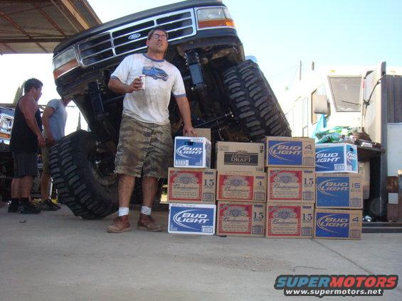 1992 Ford Bronco front view, lifted with large tires, man with beer, beer cases