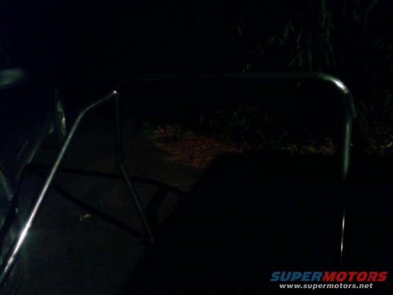Chrome trim and part of a dark-colored vehicle at night