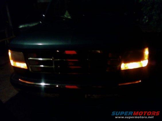 1992 Ford Bronco front grille and headlights illuminated at night