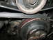 1985 Ford Mustang - Close-up view of engine belts and pulleys, showing signs of wear and rust.