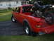1997 Ford Ranger - A red 1997 Ford Ranger pickup truck is shown from a three-quarter front angle, with a motorcycle loaded in its bed.