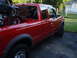 1997 Ford Ranger - Red 1997 Ford Ranger pickup truck carrying a motorcycle in its bed.