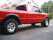 1997 Ford Ranger - Side profile of a red 1997 Ford Ranger pickup truck parked on asphalt.