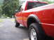 1997 Ford Ranger - A red 1997 Ford Ranger pickup truck is seen from the rear quarter angle on a paved driveway.