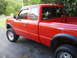 1997 Ford Ranger - A red 1997 Ford Ranger pickup truck is shown from the side, parked on an asphalt surface.