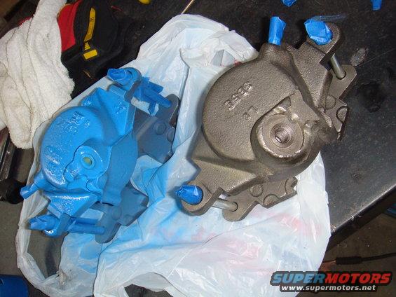 Two brake calipers, one blue, one gray, on a plastic bag