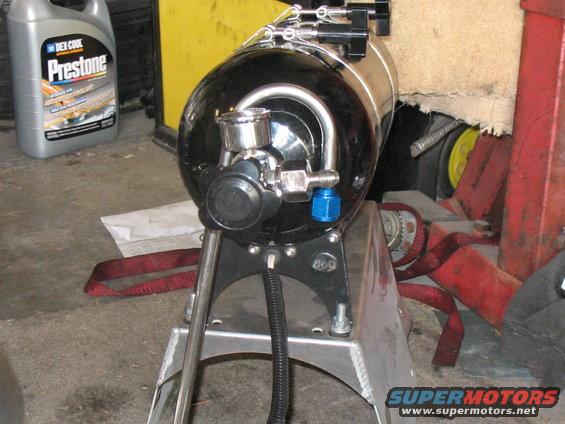 Black and chrome automotive part on a stand, with a Prestone bottle in the background