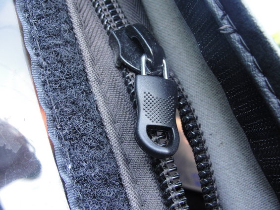 Zipper pull and hook-and-loop fastener on dark fabric