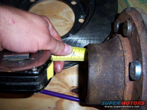 Rusty hub assembly with a tape measure across a brake rotor