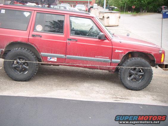 Red 1998 Jeep Cherokee with "Sport" and "Cherokee" badging, lifted suspension, and off-road tires