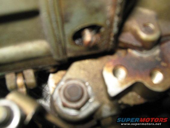 Close-up of engine components, showing bolts and metal brackets