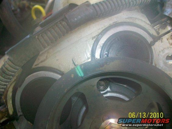Close-up of engine pulley and timing cover with green marker on belt