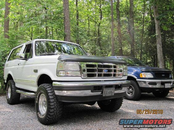 White 1996 Ford Bronco with lifted suspension and off-road tires parked outdoors